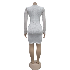 Detail of the back zipper and rhinestone embellishments on a white bodycon dress