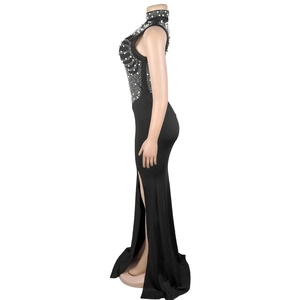 Detailed view of black high-slit dress with sparkling rhinestone wave pattern on mesh neck