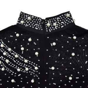 Close-up of black mesh neckline with pearls, rhinestones, and invisible zipper back