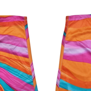 Dettaglio di abito con motivo a onde multicolore con toni arancio e rosa e cuciture bianche