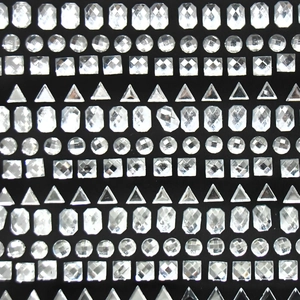 Dettaglio di strass in cristallo assortiti con tagli geometrici su sfondo nero