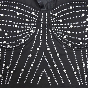 Détails de perles et de strass sur une robe en résille noire avec fermeture à glissière