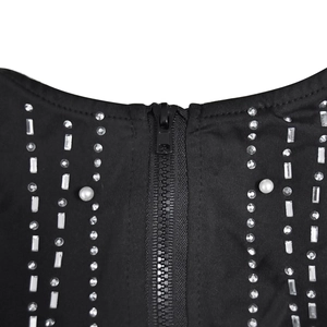 Détails d'une robe en mesh noir avec fermeture éclair, strass et perles blanches