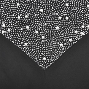 Detailed macro view of white pearls and sparkling rhinestones on black mesh fabric dress