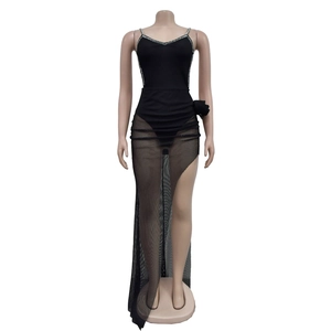 Detail eines eleganten schwarzen Netzkleides mit asymmetrischem Schlitz und Strass