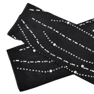 Détail de la manche en mesh noir avec strass scintillants et perles d'imitation blanches