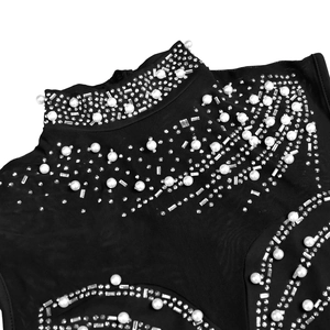 Detailed close-up of rhinestone and faux pearl embroidery on black mesh neckline