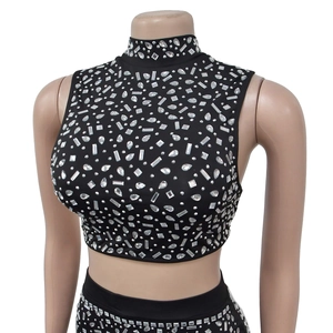 Détail du haut noir sans manches à col montant avec strass argentés et paillettes brillantes