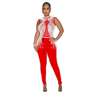 Detail of red sleeveless jumpsuit featuring rhinestone patterns and sheer mesh insert