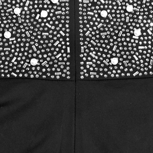 Macro detail of black mesh evening dress featuring sparkling rhinestones and white pearls