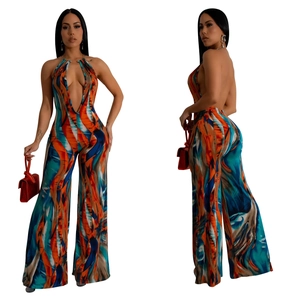 Detail of backless jumpsuit featuring colorful abstract print and deep V-neckline with halter metal ring