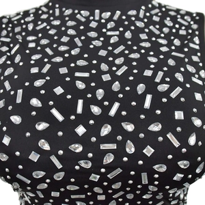 Détail des strass étincelants sur un ensemble en maille noire à col montant chic