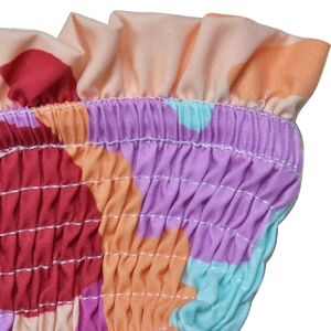 Detail of colorful smocked fabric with elastic gathers and vibrant floral print