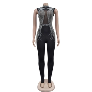 Detail of black mesh jumpsuit featuring sparkling rhinestones and sleeveless high neck design
