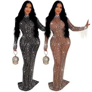 Détail d'une robe en maille transparente avec strass, col montant et pompons aux manches