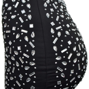 Gros plan sur le tissu extensible noir orné de strass luxueux de formes variées et scintillantes