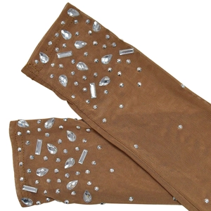 Close-up of brown mesh arm sleeves with sparkling rhinestones in various shapes