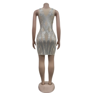Dettaglio dell'abito in mesh beige con strass argentati brillanti e motivi geometrici