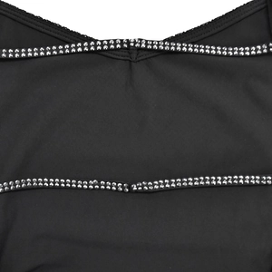 Detail eines schwarzen Strickkleides mit doppelten Trägern und funkelnden silbernen Steinen