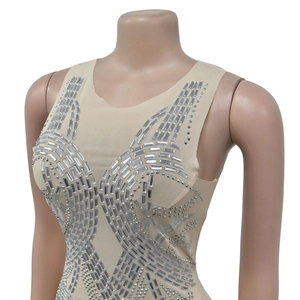 Dettaglio del tessuto a rete velata con strass argentati geometrici su un abito beige