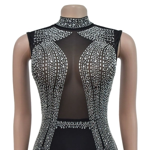 Detail of black sleeveless jumpsuit featuring mesh patchwork and silver rhinestone patterns