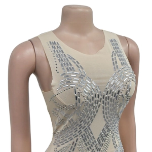 Dettaglio di abito in rete trasparente con strass argento in motivi geometrici su beige