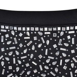 Détails macro de strass étincelants de formes variées sur un tissu en maille noire