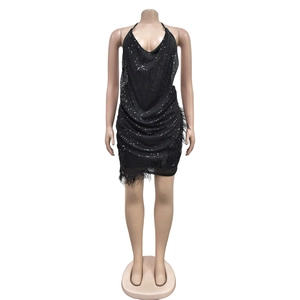 Détail d'une mini robe noire à paillettes avec col licou et finition en plumes au bas