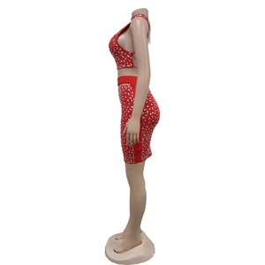 Vue latérale du haut court à strass rouges et de la mini-jupe assortie sur mannequin