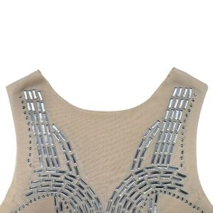Dettaglio dello scollo in mesh con strass argentati brillanti in un motivo a raggiera