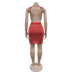 Détail de l'ensemble rouge deux pièces avec chaînes dorées au dos et sequins argentés