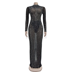 Gros plan des strass argentés sur la maille noire transparente d'une robe longue de luxe