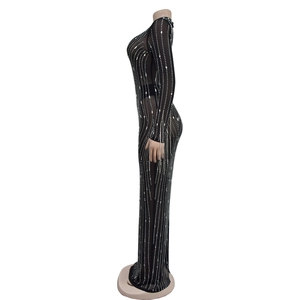 Détail de robe longue en maille noire avec strass argentés et coupe moulante élégante