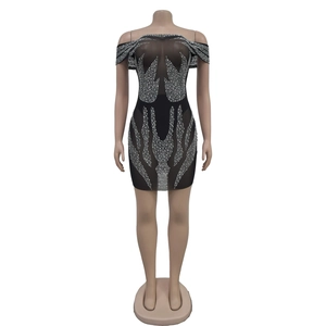 Détail de la robe courte noire transparente avec strass argentés à motif de flammes