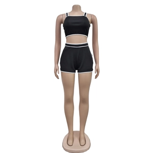 Detail shot of black two-piece sports set with contrast white piping and elastic fabric