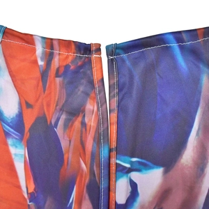 Detail of colorful geometric print fabric with reinforced white stitching on jumpsuit