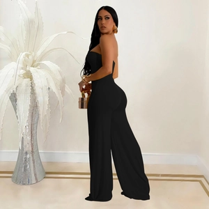 Detail of elegant black strapless wide-leg jumpsuit with slim fit and draped fabric