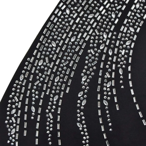 Detail of black fabric embellished with sparkling geometric rhinestones and crystals