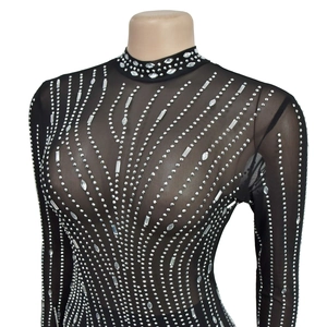 Détail de la robe en mesh noir transparent avec motifs de strass scintillants