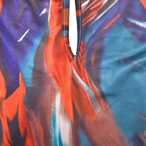 Detailed close-up showing vibrant abstract print fabric with white stitched seams on edges