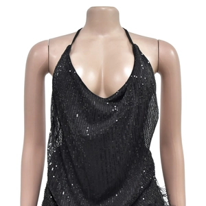 Détail du haut noir à paillettes avec col bénitier offrant une texture scintillante sur mannequin