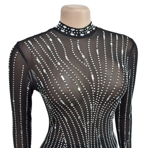 Détail de la robe en maille noire avec strass argentés brillants et col montant élégant