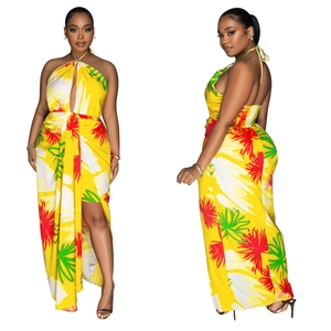 Detail of yellow backless halter dress with vibrant tropical floral print and high slit