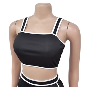 Detail of square neck crop top with white contrast piping on black ribbed fabric