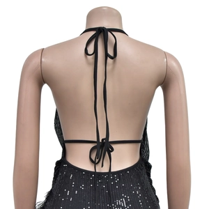 Détail de la robe noire à paillettes avec bordure en plumes et dos nu à nouer chic
