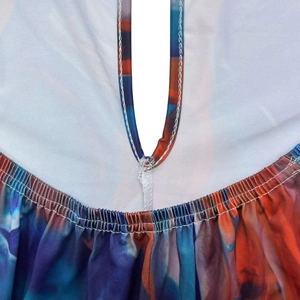 Detail of printed jumpsuit featuring a keyhole neckline and elastic pleated stitching texture