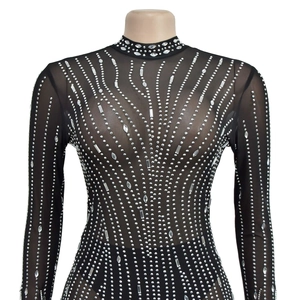 Détail du haut en tulle noir avec des motifs ondulés de strass argentés brillants