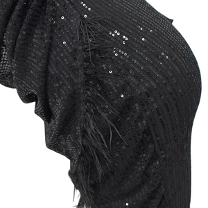Détail de sequins noirs denses et de bordures en plumes élégantes sur l'ourlet de la robe