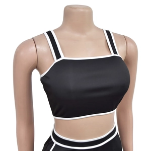 Detail of black sporty set with white contrast piping on the crop top and shorts