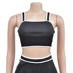 Close-up of slim fit two-piece set with black fabric and white contrast piping detail